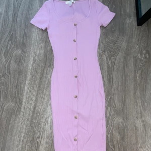 Klänning - Lila, ribbad, går över knäna och lite längre ner, knappar men går ej att öppna dem, t-shirt modell. Fungerar som S och Xs Kontakta för mer info/fler bilder. Kan postas men köpare står för frakten. Kan mötas upp i malmö. 