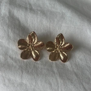 Blom örhängen!! - Säljer dessa sjukt snygga guldiga blom örhämgen😍😍 köpte dem för ett tag sedan säljer då dem tyvärr inte har kommit till använing❤️