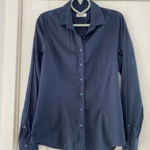 Ny marinblå skjorta från Stenströms i strl 38, modell Ferminine - Ny marinblå skjorta från Stenströms i strl 38, modell Ferminine.  Endast tvättad, aldrig använda.  Mått Över bröstet: ca 51 cm Längd från axeln och ner: ca 66 cm  97% bomull och 3% elastan