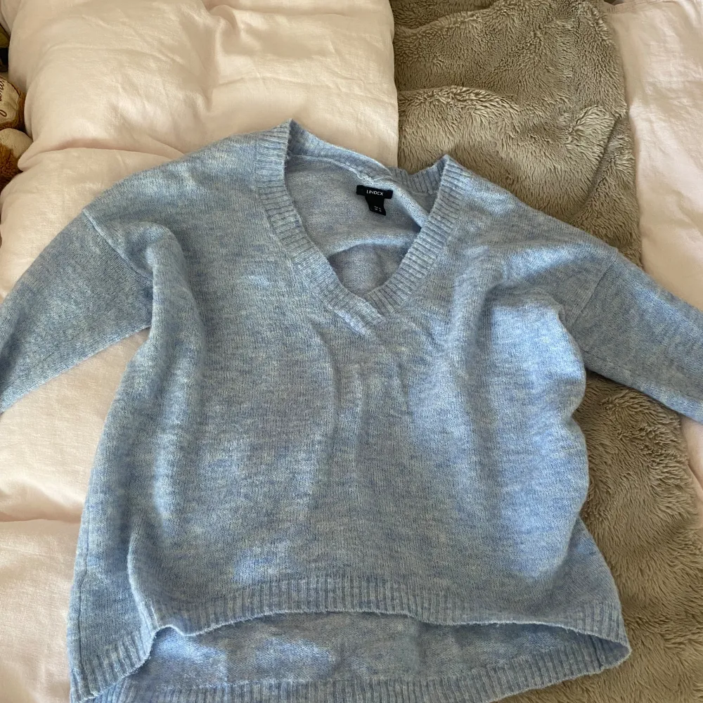 Jättefin ljusblå stickad tröja med v- ringning 🎀 Lite croppad med längre baksida, strl XS, inga defekter förutom en aning noppig 🫶🏼. Stickat.