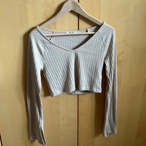 Ribbad topp - Ribbad och croppad topp, med slits i armslutet, använd sparsamt 