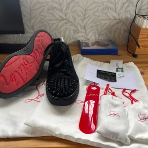 Svarta sneakers från Christian Louboutin - Ett par svarta sneakers från Christian Louboutin. skick 9/10. Inga defekter förutom lite smutsigt på den röda sulan men går lätt att tvätta bort. PRISET ÄR INTE HUGGET I STEN.Storlek 40 men passar även 41, 42. har inte använt de så mycket eftersom jag fick ett par andra skor och så har jag växt ur dem. kontakta kring fler frågor och funderingar