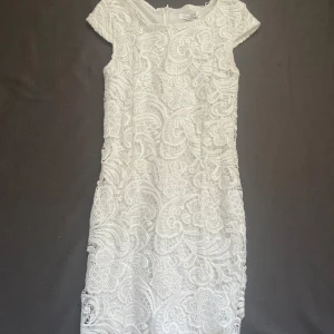 Vit spets-klänning -  mellan lång vit spetsklänning med dragkedja bak, perfekt när skolavslutningen är påväg😍🤍