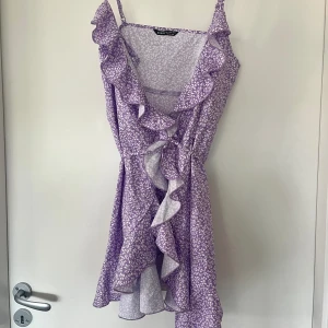 Lila klänning  - Oanvänd, står strl L men är som en S. Osäker hur man knyter den korrekt så därför bara en knut på bilden  😂