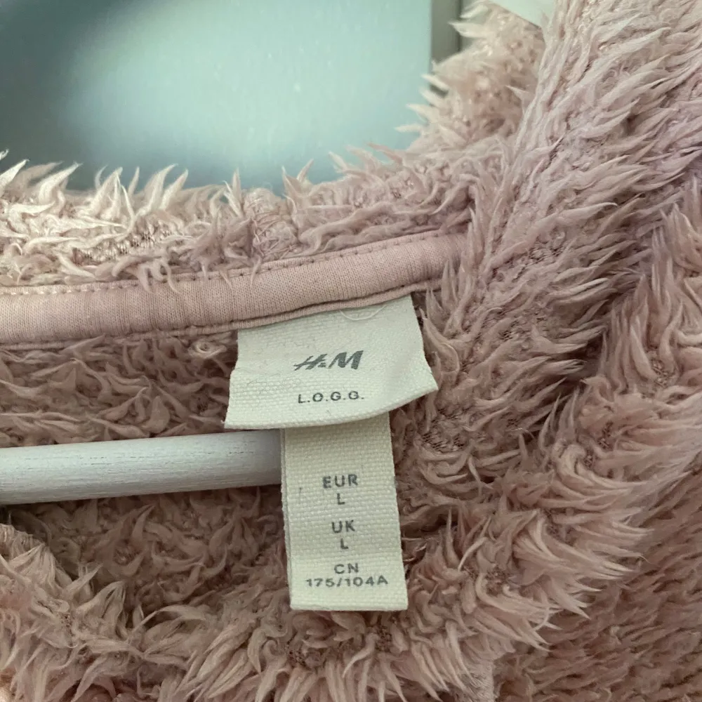 Supermysig rosa fluffig hoodie. Köpt på H&M. Storlek L men skulle säga att den motsvarar en M. Jättemjuk och varm.. Hoodies.