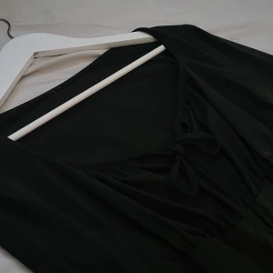 Svart långärmad topp - Svart topp med en "lösare" byst som man knyter i mitten, ganska tunn och bra för sommaren🖤🖤