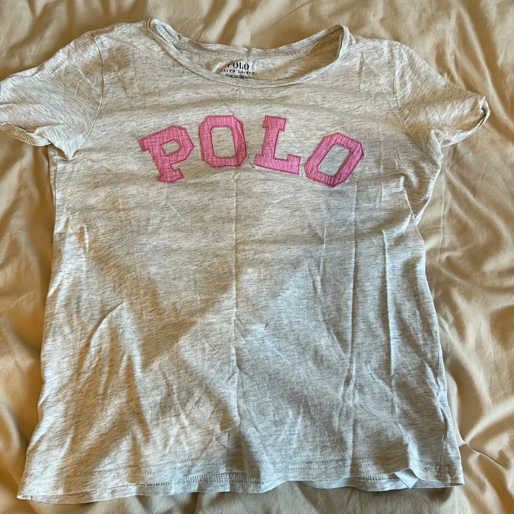 En jätte gullig rosa grå Ralph lauren tröja. Säljer för den är för liten. Skicket är bra. Jätte gullig nu till sommaren . T-shirts.