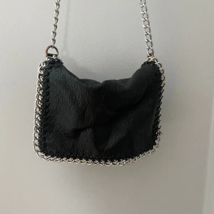 Svart Tiamo väska - Säljer min tiamo väska som jag köpte på plick för att den inte används. Den är i okej skick eftersom kedjan rostat lite. 