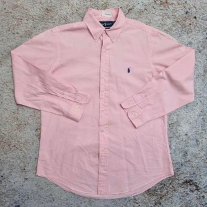 Polo Ralph Lauren skjorta - Button Down Shirt  - Skjorta från Ralph Lauren i storlek S. Den är i väldigt bra skick och har inga defekter. Ny pris är 1295 kr och vårt pris är 349 kr. Vid frågor eller funderingar tveka inte att höra av er.  Passa på nu!