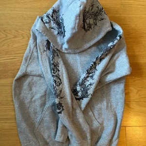 Hoodie med tryck!  - Grå skön y2k hoodie med tryck på armar och luva! Köpt begagnad men i väldigt bra skick! Från märket TOPMAN. 