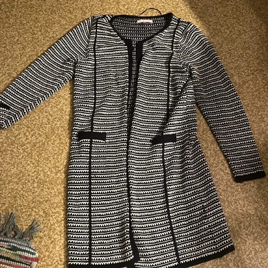 Svart kofta med vita detaljer