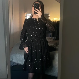 Svart klänning med silverdetaljer - Superfin klänning med glittrande mönster av silver!✨ Strl M på klänningen men kan passa en storlek S då jag själv pendlar däremellan;) 