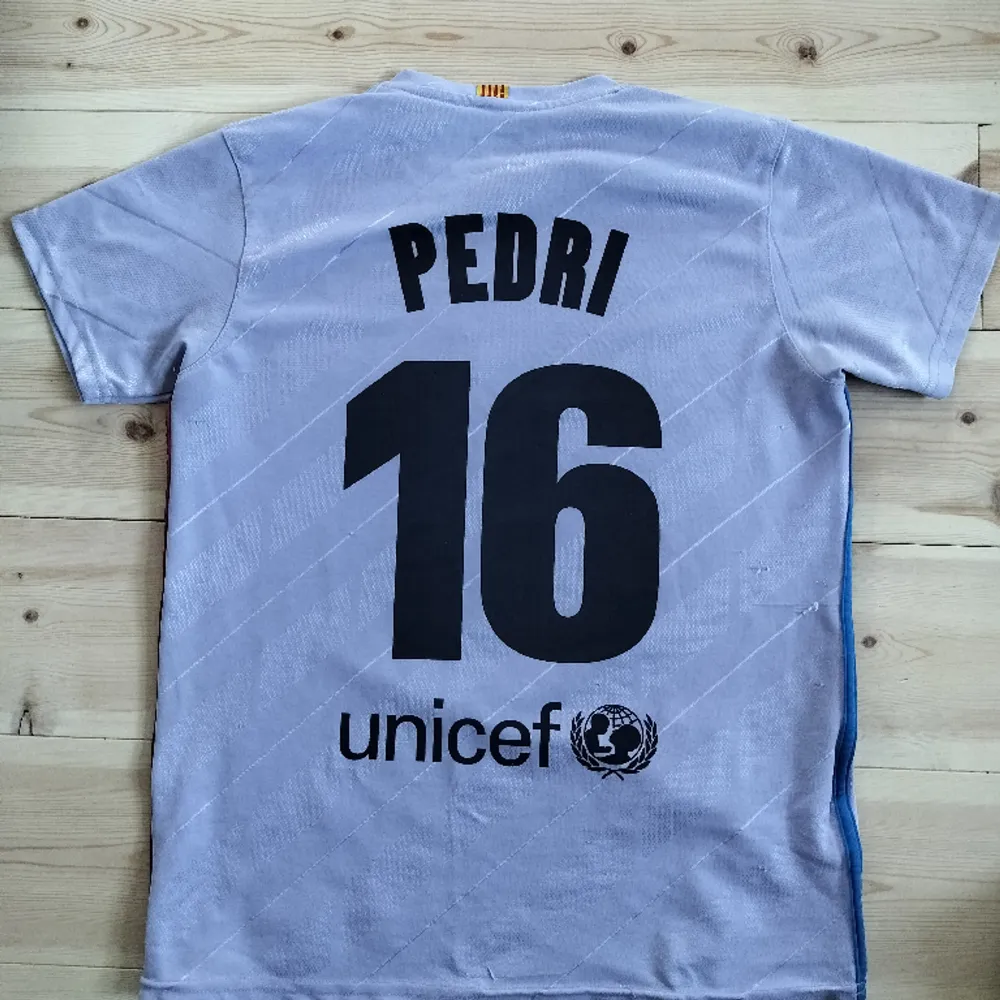En Pedri tröja från säsongen 2021-22. Lite sliten men ändå bra skick. Lite lila blå i sin färg. T-shirts.