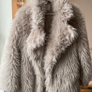 Pälsjacka - Supersnygg pälsjacka i en grå-beige färg från H&M. Sparsamt använd. Skriv om du vill ha flera bilder.😊 pris kan diskuteras