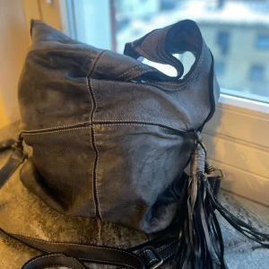 Designväska Italiensk  från Caterina lucchi  - Fin väska från Caterina lucchi. Inga skador eller så. Vintage.  Man kan välja att ha den mindre genom att den dubbelviks,  eller fylla den och ha den som större väska.  Läder   Nypris 3500  45 hög x 37 bred  när den ligger platt 