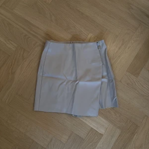 Skinnkjol från Zara - Så söt beige skinnkjol från Zara! Är en kjol med inbyggda shorts🤍