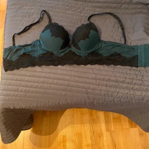 Bh - Mörkgrön lite längre bh, tyvärr är lappen bort klippt så jag vet ej vart den kommer ifårn eller storlek, men jag skulle tippa på att den är 65-70 A/B, lute sliten finns bilder i slutet, lite puch upp