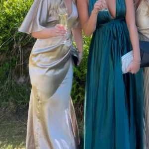 Balklänning  - Säljer denna superfina champagnefärgade balklänningen (till vänster). Inga fläckar, hål eller liknande. Lite smått fransig längst ner vid släpet men det är på insidan så det syns inte.  Jag är 167cm och den är bra i längd på mig. 