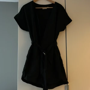 Jumpsuit från Weekday - Snygg, svart, shorts-jumpsuit med skärp i midjan från Weekday. Använd en gång pga lite stor men väldigt fin. 250kr exkl frakt 💕knäpps med knappar