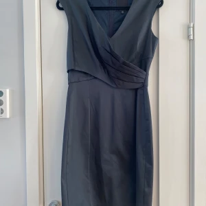 Svart glansig klänning i strl 38 från Inwear, modell Aleens - Svart glansig klänning i strl 38 från Inwear, modell Aleens.  Endast använd en gång och är i väldigt fint begagnat skick.  Mått Över bröstet: ca 46 cm Längd från axeln och ner: ca 97 cm  95% polyester 5% elastan  Kommer från ett djur och rökfritt hem