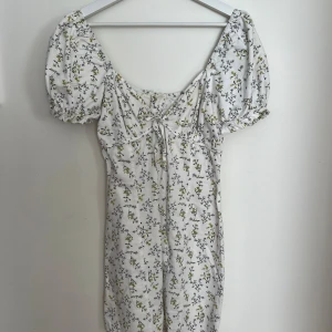 Blommig klänning 36 - Säljer denna blommiga klänning i denim (storlek 36) och har puffiga ärmar.  Skitsnyggt när man har offshoulder. Köpt från missguided, använd 1 gång.