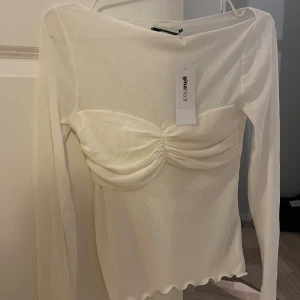 Boatneck top - Superfin boatneck top i lite genomskinligt material med extra tyg över bysten som är en cool detalj. Funkar lika bra fest som vardags. Aldrig använd, endast testad. Prislapp är kvar, köpt för 299 kr. 