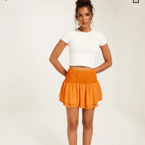 Volangkjol - Orange kjol med smock och volanger från Vero Moda. Endast använd 1-2 gånger så ser i princip helt ny ut. Nypris: 279 kr. Mitt pris: 70 kr.