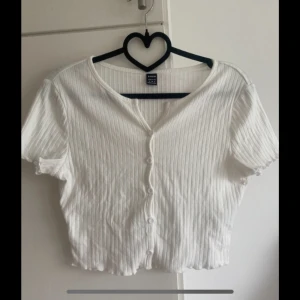 Midjekort topp - Midjekort topp med knappar och volang kant. Ej använd