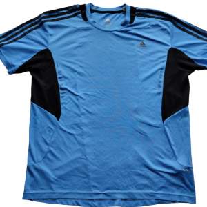 En blå svart Adidas T-shirt vintage i strl XXL men passar även om man har XL. I mycket fint begagnat skick. 