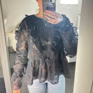 Blus - Svart blus med volang från hm. I strl 44 men sitter perfekt på mig som annars är 34/36. Använd en gång.