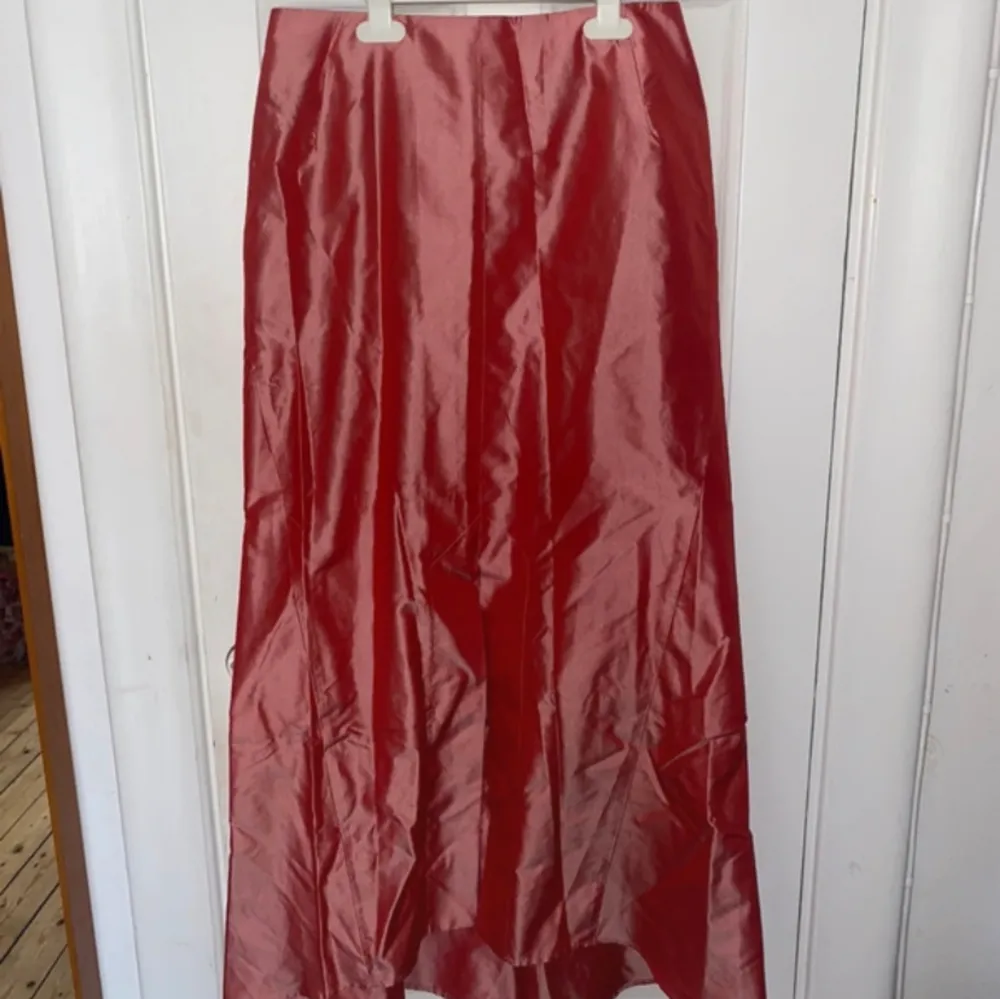 Så snygg lång röd kjol i glansigt material! ❣️knappt använd och i mycket fint skick . Kjolar.