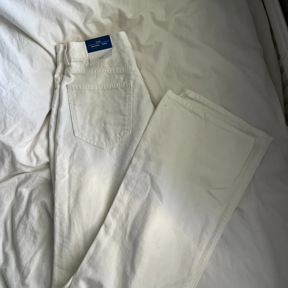 Helt nya vita jeans från bershka, dom har ett hål i båda knäna, modellen är flare men ser rätt så bootcut ut.. Jeans & Byxor.