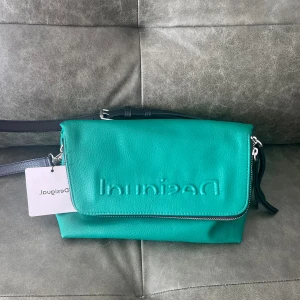 Grön Desigual väska!! Ny!! 🫶🏼🫶🏼 - Grön Desigual väska, helt ny med prislapp! Säljs då den inte kommer till användning. Inga fel, be gärna om fler bilder. Pris kan diskuteras. 