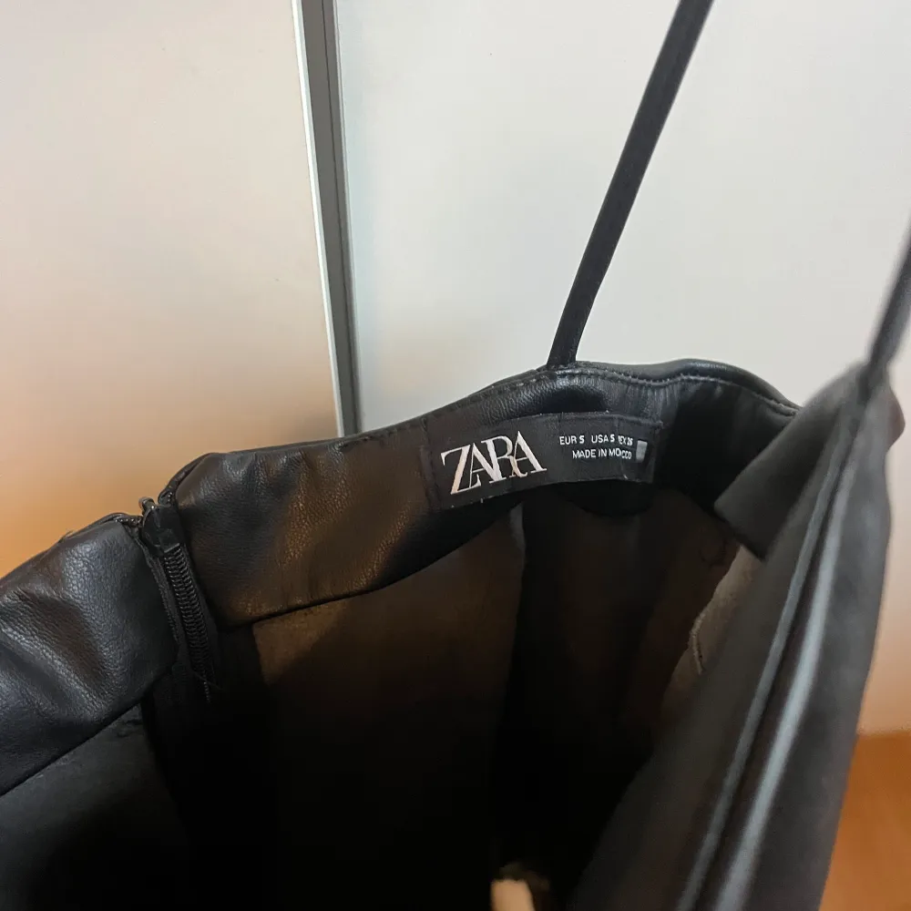 Svart miniklänning från Zara i läderimitation. Använd en gång, kasar inte upp när man går🖤  -Draperad   -lite stretchig   -spagettistraps  Skorna säljs också! . Klänningar.