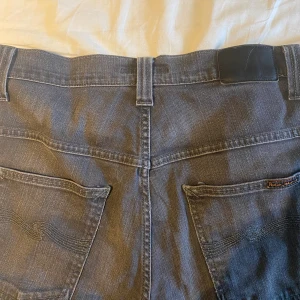 Nudie jeans - Ett par riktigt feta nudie jeans (thinn Finn) i färgen mörkgrå. Jeansen har använts ett tag men är fortfarande i väldigt bra skick. Min kompis på bilden är ca 175. 
