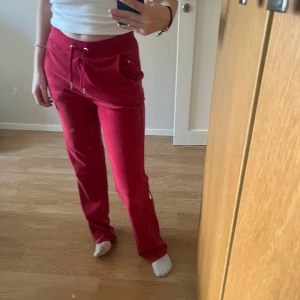 Juicy Couture  - Röda Juicy Couture byxor med stenarna där bak. Säljes då dom inte kommit till användning. Väldigt bra skick! Några av dem skönaste byxorna jag haft på mig. Sitter som S/M Nypris: 1 200kr