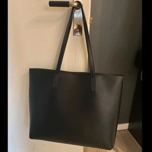 Stor handväska  - Stor och rymlig handväska. Väskan är öppen upptill men går att ”stänga” med en magnet. Den har även ett litet sidofack på insidan. Köpt på Zalando förra året för 300kr. Väskan är knappt använd och är därför i nyskick. Priset kan diskuteras💕