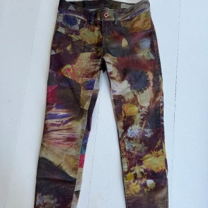 Flerfärgade jeans från Diesel, strl 25’ - Flerfärgade jeans i brända toner från Diesel. Smala (inte skinny) i 5-ficksmodell. Mycket fint skick.
