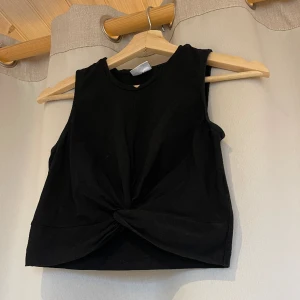 Svart topp - Söt svart topp med detalj fram (se bild) i Strl S.