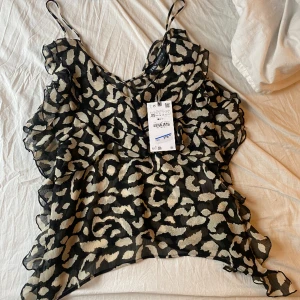 Zara blus - Säljer denna ursnygga zarablus! Den är i storlek XS men stor i storlek!! Helt ny med prislapp kvar, nypris är 379kr. Den har långa axelband och är lite genomskinlig.💘💘