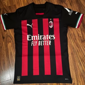 AC Milan 22/23 kit - En skitsnygg AC Milan fotbollströja från säsongen 22/23 helt oanvänd. Den är köpt på stadium i Stockholm vilket betyder att den är hundra procent äkta. Tveka inte att höra av dig vid frågor!