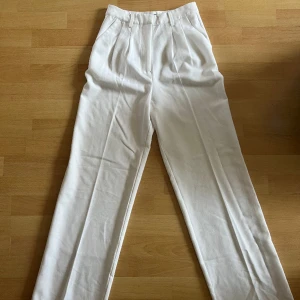 Vita kostymbyxor - Bikbok - Vista kostymbyxor (högmidjade) från Bikbok i strlk 36. Knappt använda så dom är i mycket gott skick. 