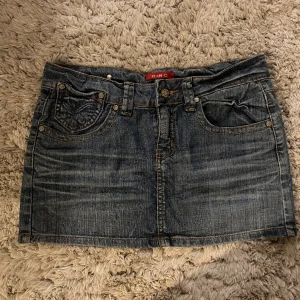 C-IN-C jeanskjol - Snygg jeanskjol. Står storlek 27 inuti. Midjemåttet är 37cm tvärsöver. På bild 3 ser man bytte små hål men inget som tydligt syns. Knappen är lite lös men går fortfarande att använda !!