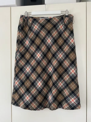 Midikjol i rutigt mönster  - Fin rutig kjol i ”burberry” stuk i ett tjockt och vart material. Är i bra skick och kvalitet