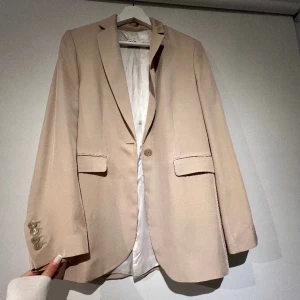Beige kavaj  - Säljer nu denna as snygga och trendiga kavajen från zara. Aldrig använt endast testad. storlek xs men är lite större i storleken. Säljer för 300kr nypris ca 600-700kr.  Hör av er vid fler bilder eller funderingar!💕