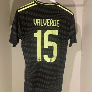 Real Madrid Valverde #15 Fotbollströja - Real Madrid 🏆 22/23 Tredjeställ 🏆 I nyskick 🏆 Valverde #15 🏆 Denna vackra fotbollströja säljer vi för 449 kronor. Hör av dig vid funderingar.