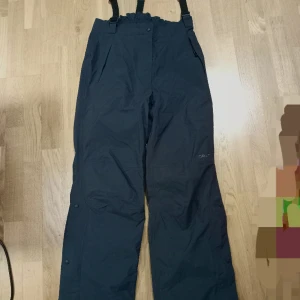 Craft vind och regn byxor strl 42 - Craft vind och regn byxor med hängslen ,storlek 42 men känns mer som 40 . Använda ett fåtal gånger. 