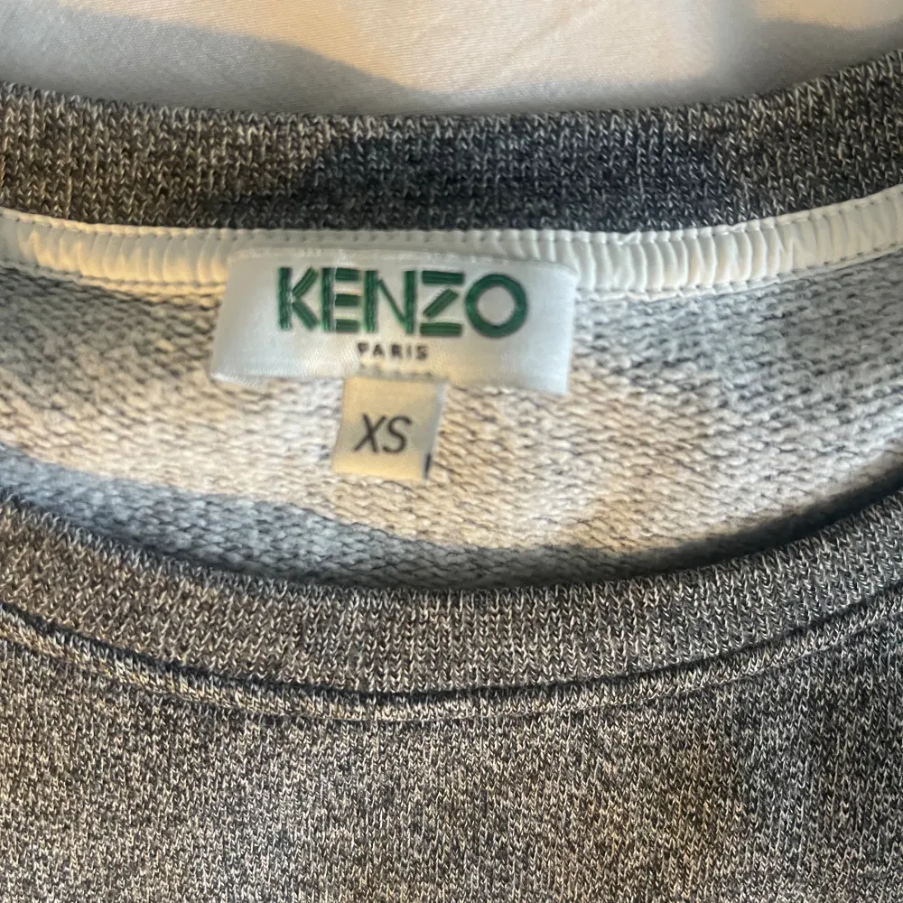 Jättefin tröja från kenzo i grått! Har ett tryck på framsidan där det står OUI, och små volanger på axlarna! Storlek ca men funkar även för s❤️ pris går att diskuteras!. Tröjor & Koftor.