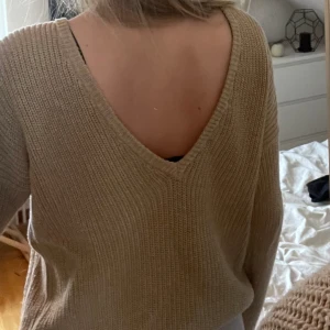 Stickad tröja, öppen rygg - Beige/brun stickad tröja från NA-KD som inte finns att köpa längre. Öppen i ryggen. Är i storlek XS men passar S/M också!💕Säljer för 159+frakt🙌🏼