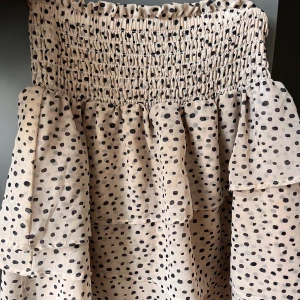Kjol - En jättesöt kjol som är benvit med svarta prickar. Den går också att ha som en topp. Använd men inga defekter!!💕